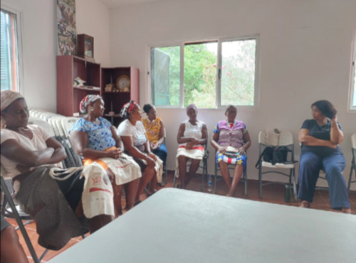 grupo de mulheres e homens reunidos ao ar livre, em um ambiente rural